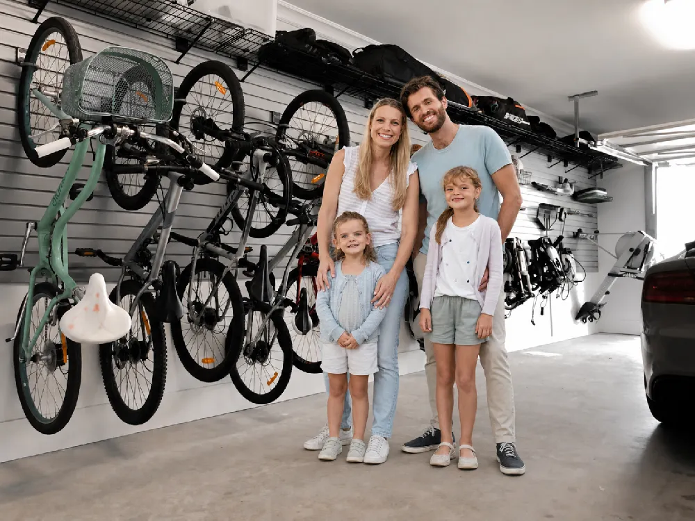 Family standing in their organised garage with bikes stored on the wall