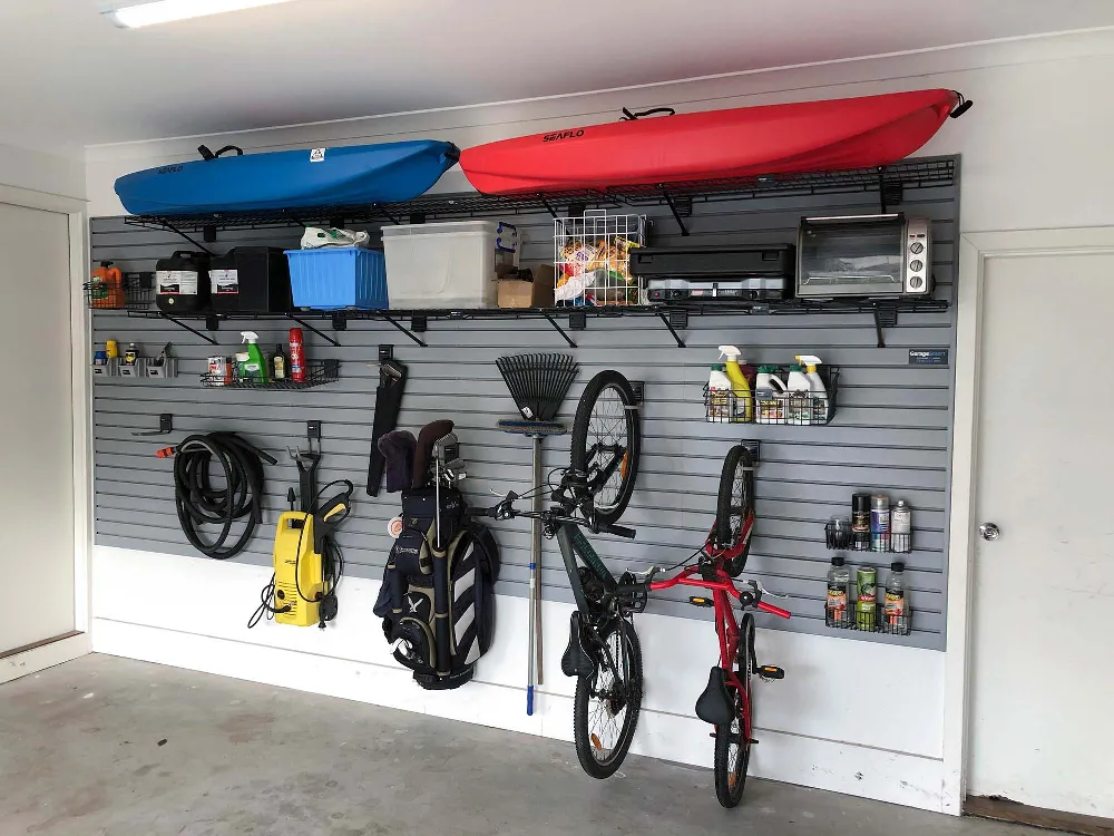 Kids bikes, scooters and sports gear stored on a garage wall